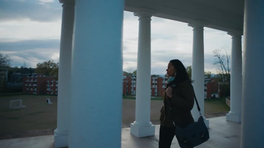 A woman walking campus during the spring time