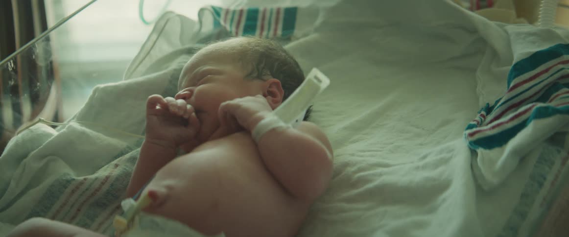 Newborn baby lies in incubator