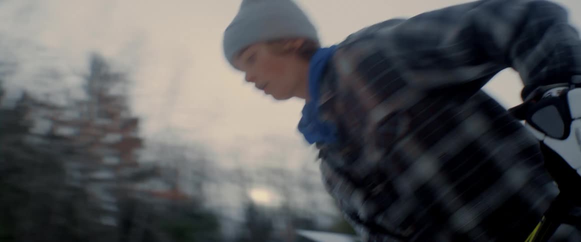 A boy guides a hockey puck across a frozen lake