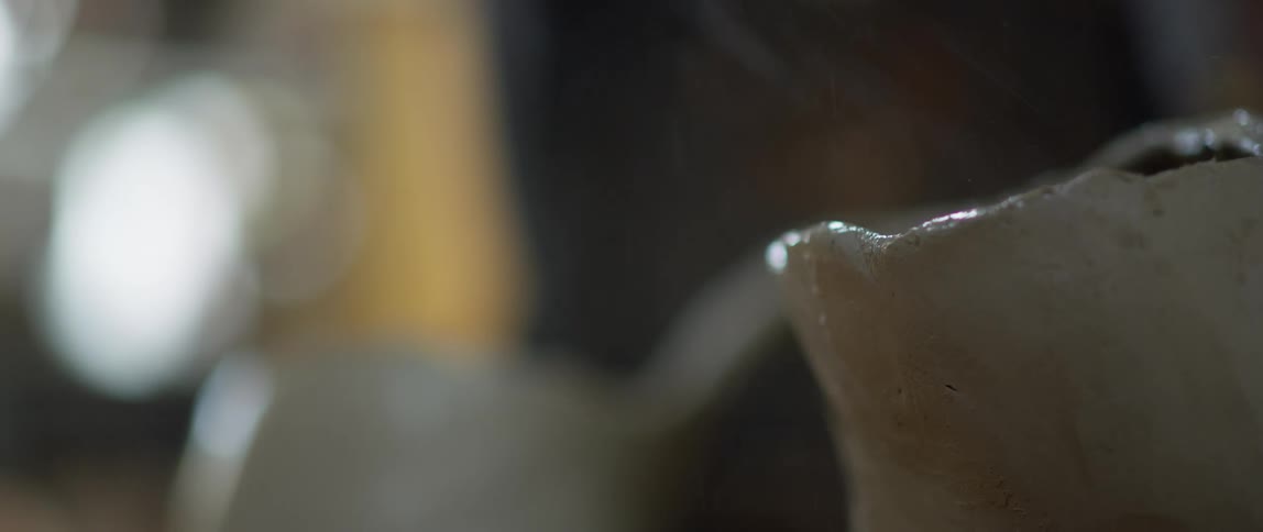 Water is being sprayed onto a white piece of pottery