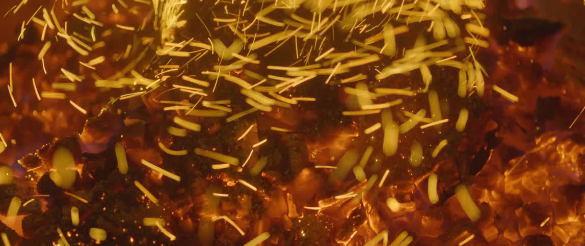 Sparks fly and glow in a furnace