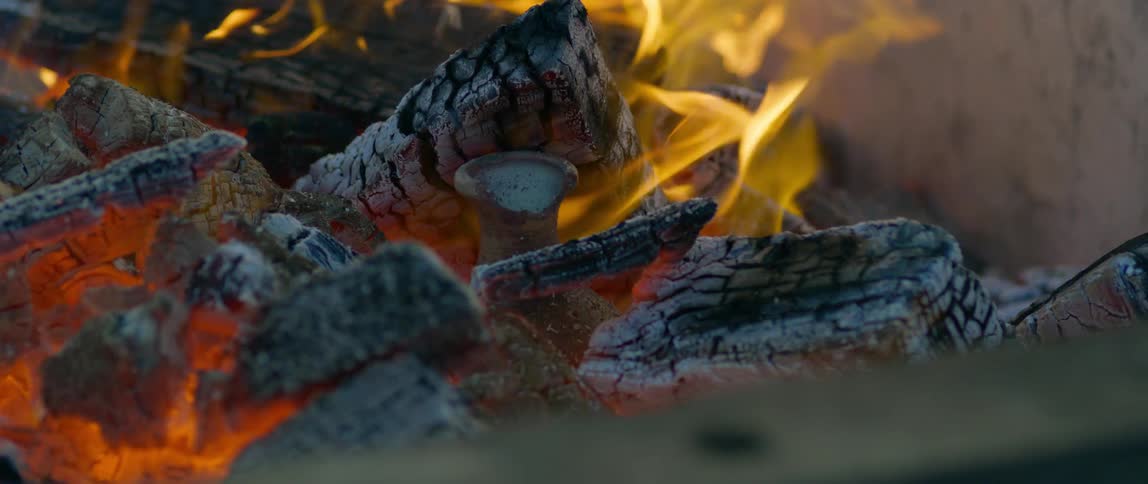 A campfire is displayed outdoors with flames