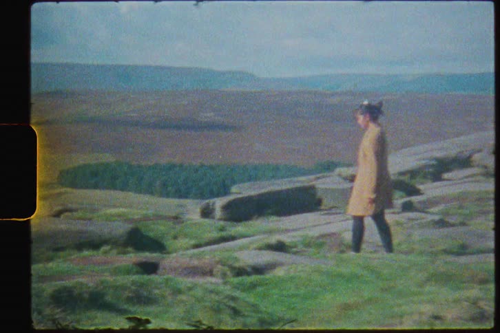 Footage of a person walking on a grassy landscape is caught on film