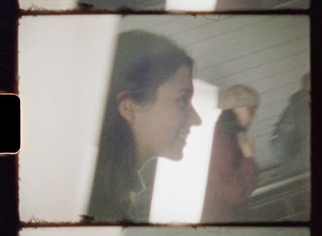 A woman smiles while riding the escalator