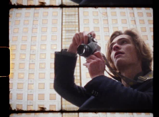 Young man uses a vintage camera to take pictures in the city caught on vintage film