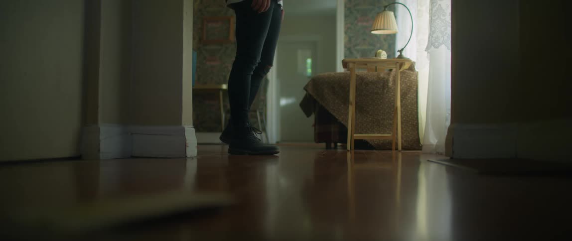 Person walks toward window and stands looking out before walking quickly away