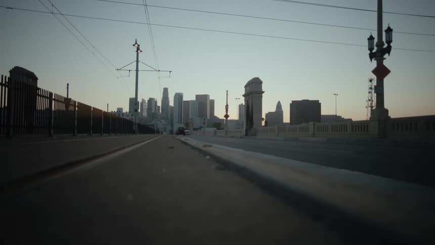 Traffic flows to and from city backed by red tinted horizon