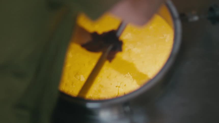 A man stirring a vat of liquid