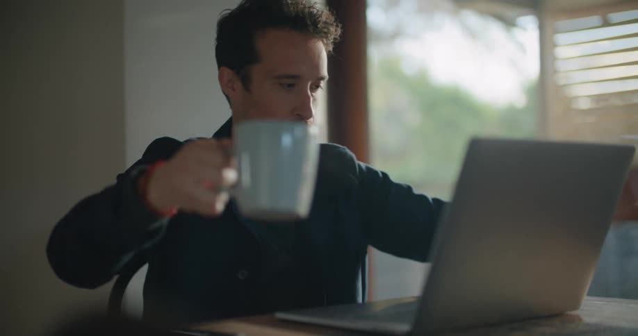 A man sitting at a table on a laptop