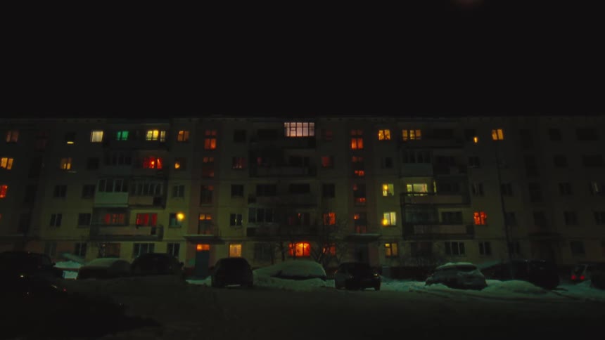 A car drives past the apartment building