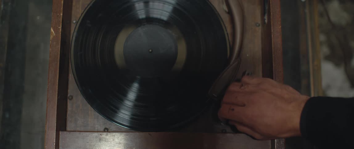 A person moving an arm on a record player