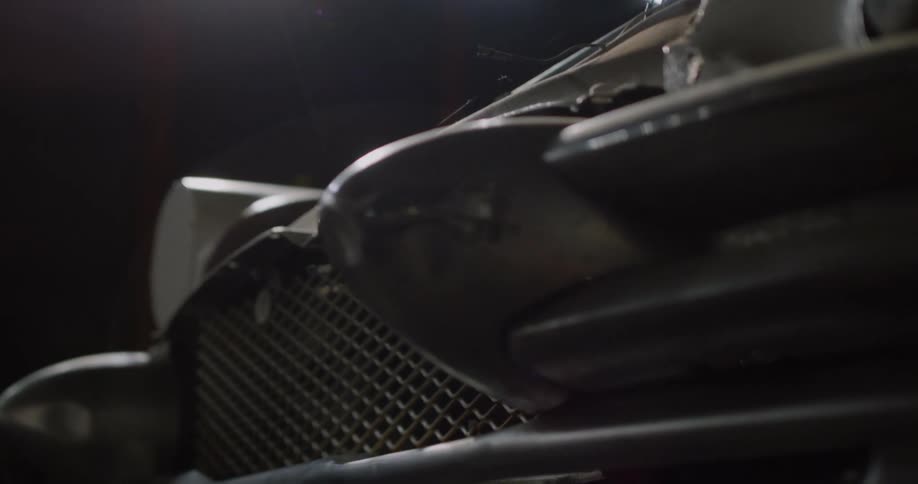 Close up of the front of a vintage car with spider webs on the hood