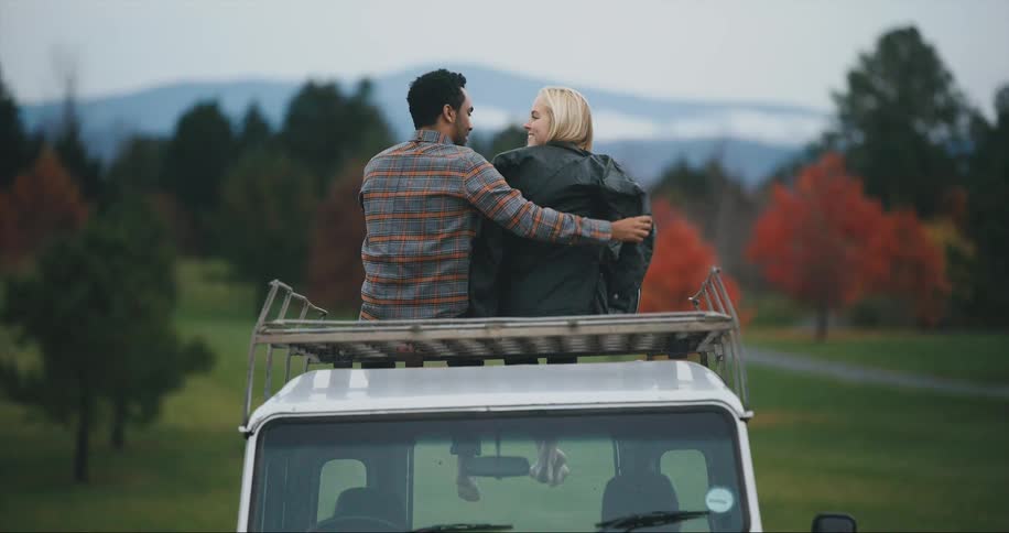 A gentleman gives woman his jacket in beautiful autumn landscape
