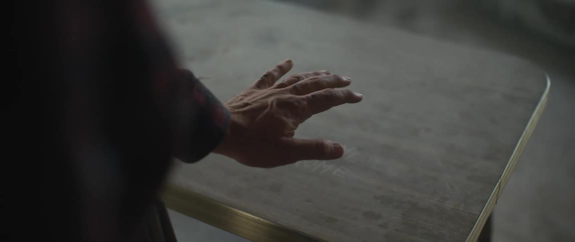 A man holds his hands over an old table