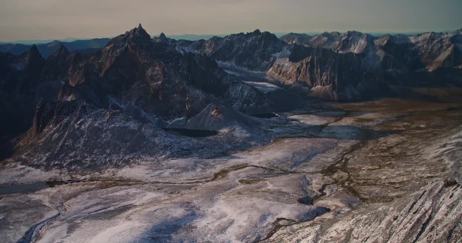 Waterways flow through valley surrounded by mountainous terrain stretching to the horizon
