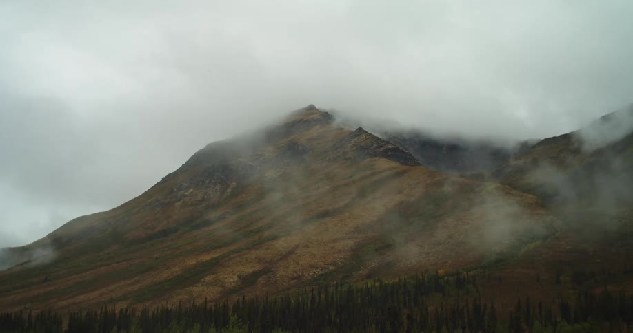 Clouds and fog move over a mountain slope and ridge