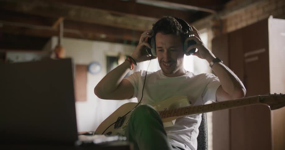 Musician stops playing electric guitar to answer mobile phone