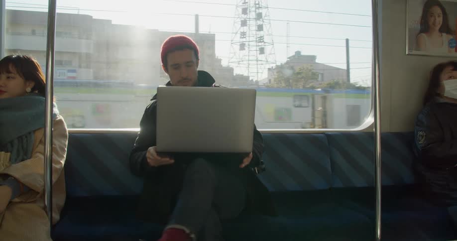 Man uses a laptop while traveling on a train