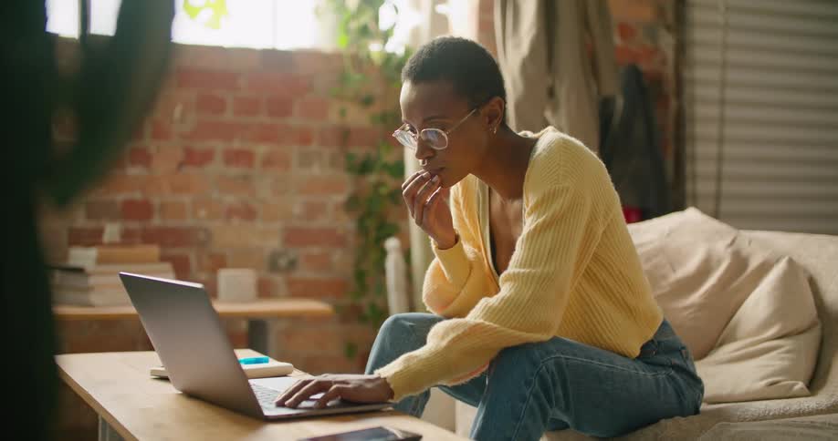 A woman using a laptop on the couch