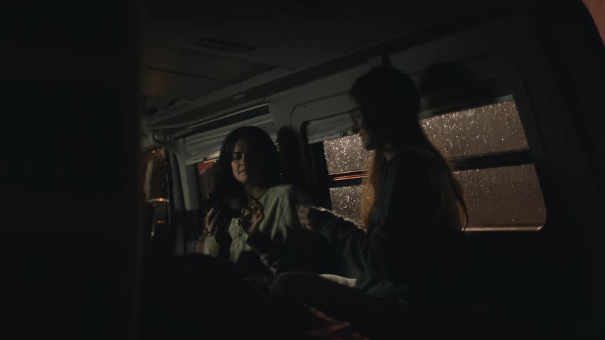 Two girls talk in the van