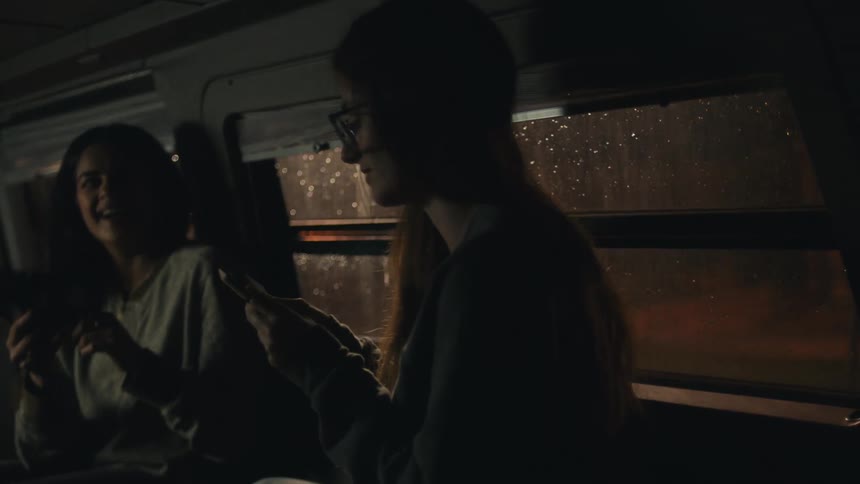 Two girls talk in the dark van