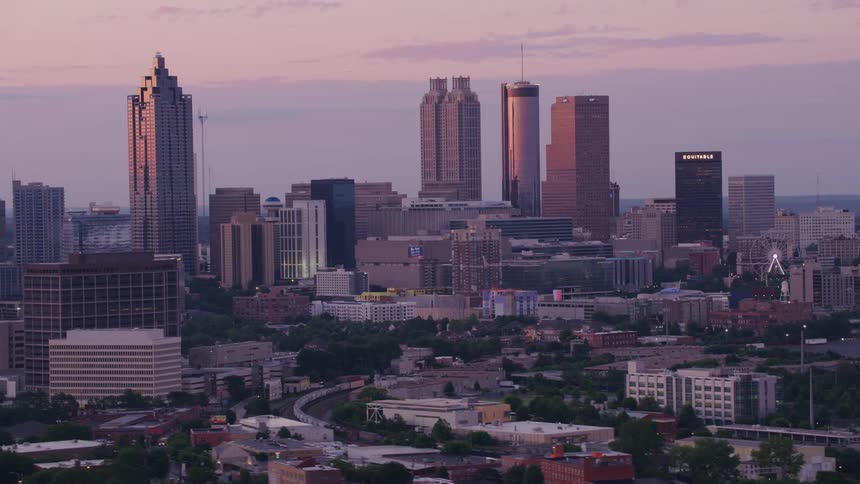 Downtown city skyscrapers are bordered by shorter buildings under a cloudy sky