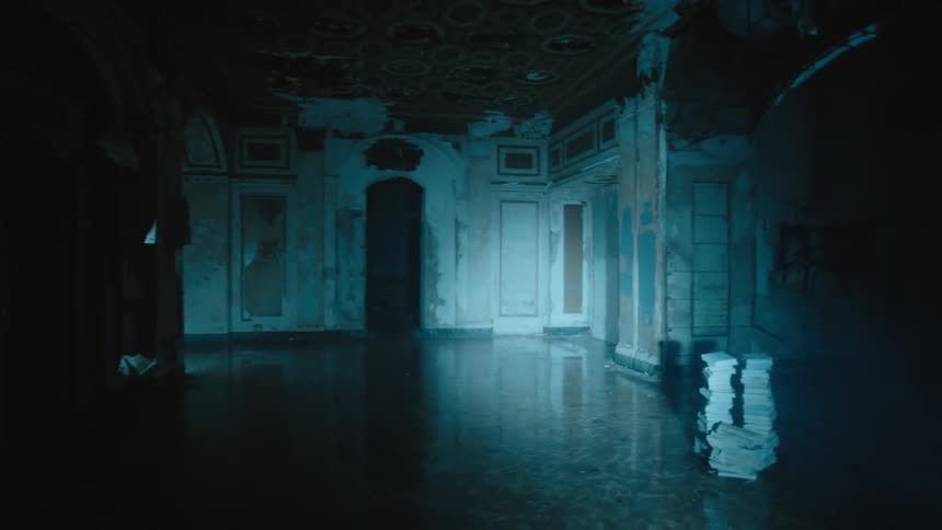 Flashlight beam illuminates ruined abandoned building revealing crouching man who walks away quickly