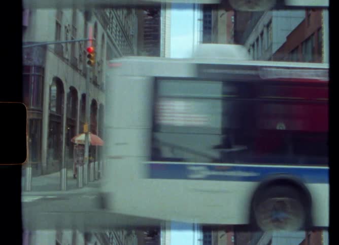 Bus drives on road at intersection passing by apartment buildings in the city