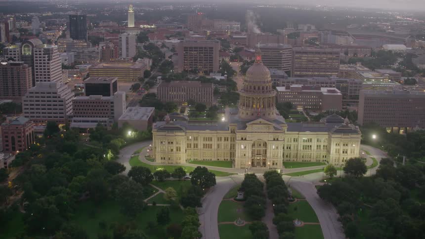 The texas state capitol building glows at dusk
