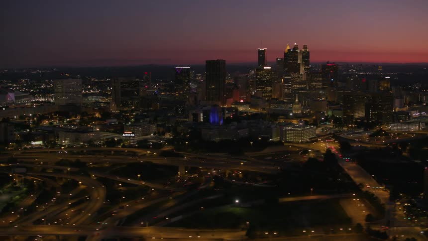 Aerial view of a downtown city at dusk is displayed