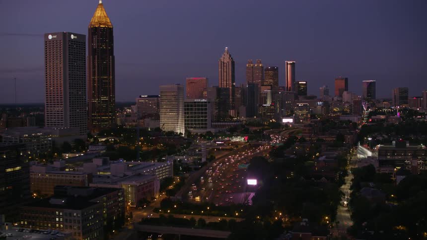 Traffic travels along a freeway through a metropolis at night