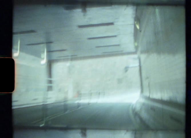 A curved narrow tunnel leads to a downtown city