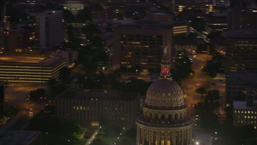 Aerial view of a downtown city at night is displayed