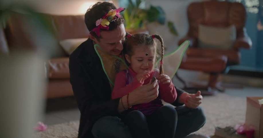 A father and daughter sitting in a room