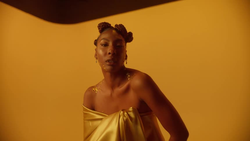 A woman is modeling and wearing a gold robe