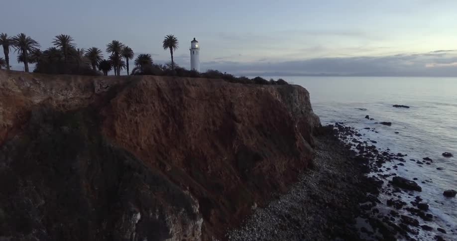 Aerial view of a coastline with a lighthouse on a cliff