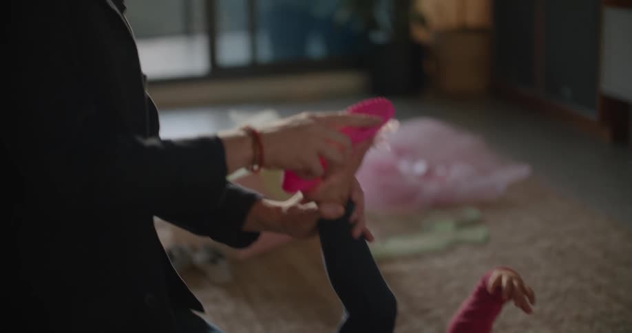 Father and toddler daughter wearing costumes playing over the rug on the living room at morning