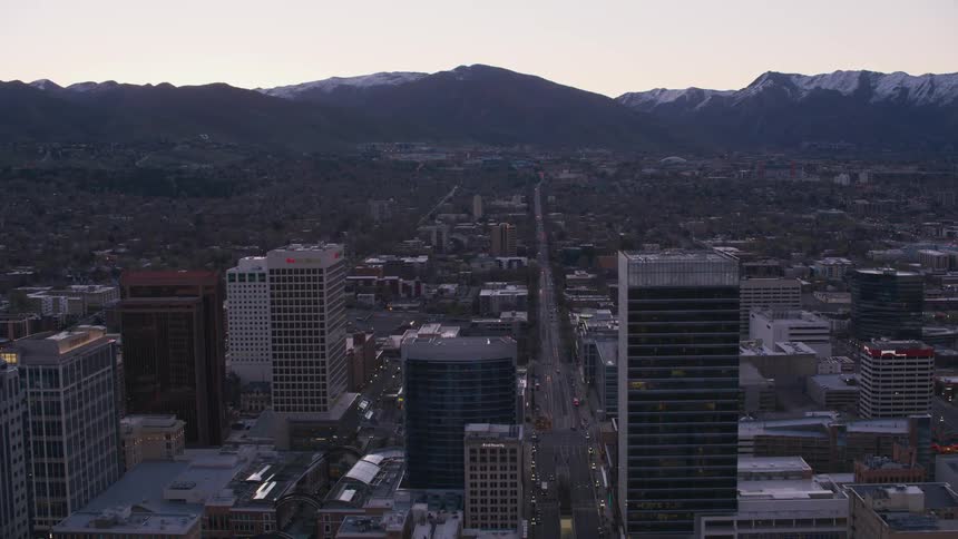 The salt lake city skyline and rooftops with snow capped mountains behind