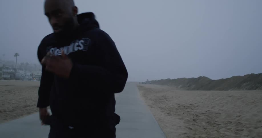 A man runs on a trail past a beach community