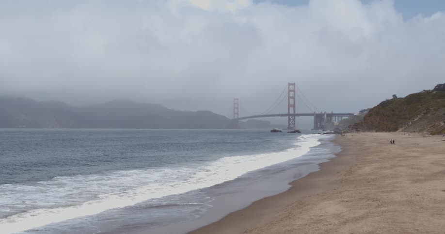 The ocean tide washes into a sandy beach during the day