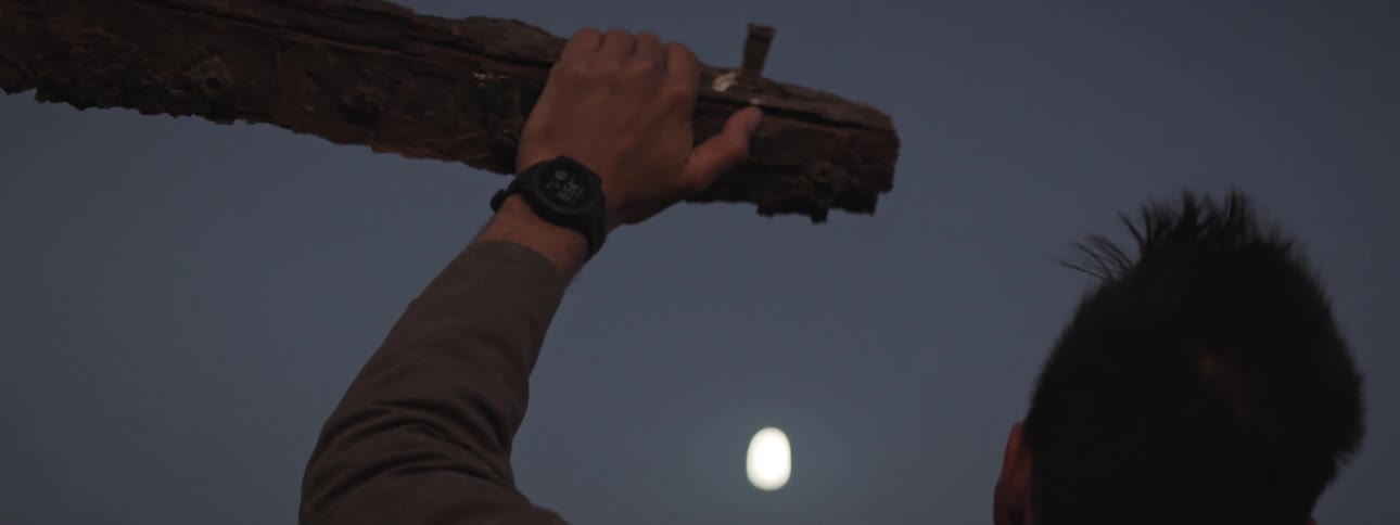 A man rests his arm under a moonlit sky