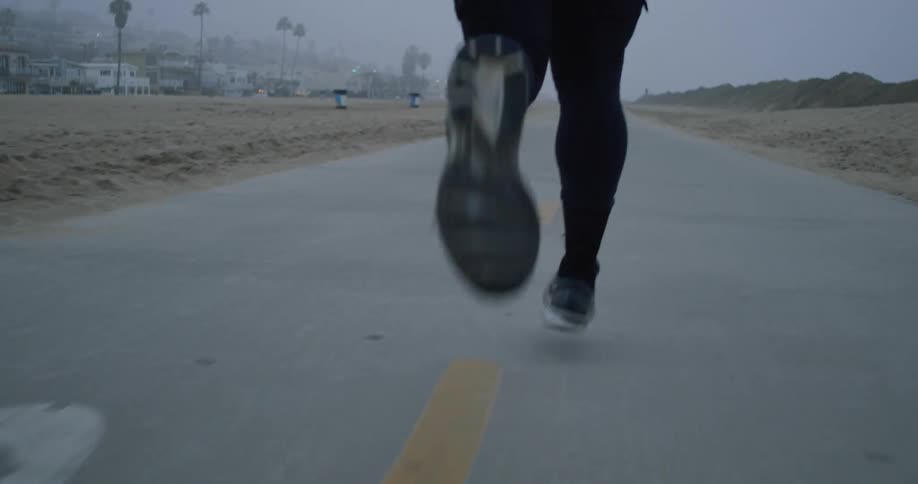 A man runs on a trail through the beach