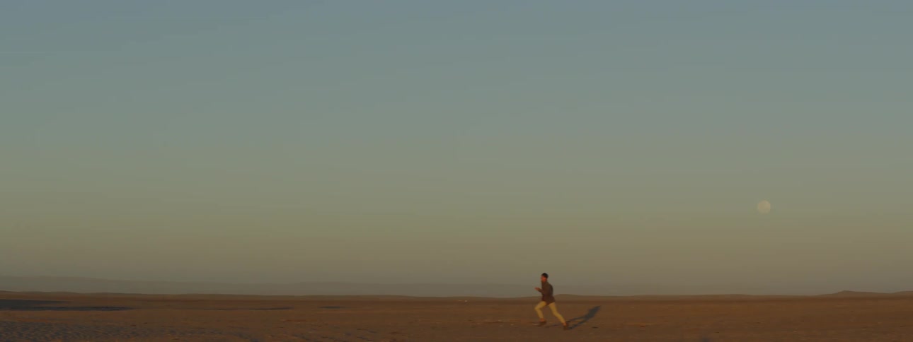 A man running through sand in a desert