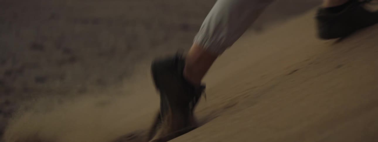 A man running up a sand dune