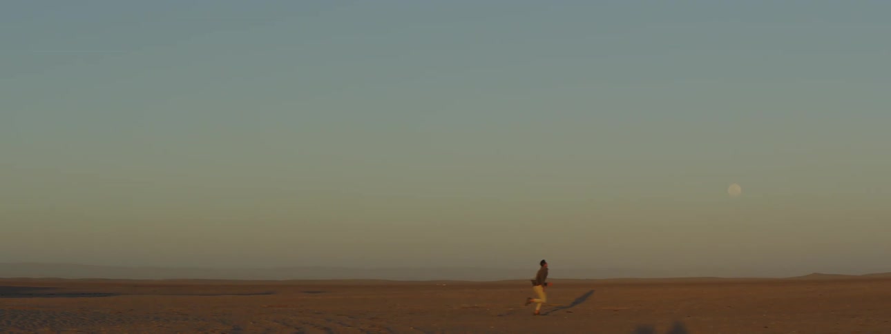 A man running in the desert at dusk