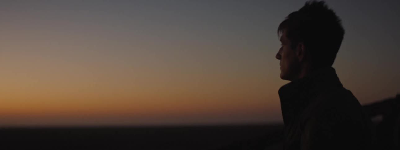 Young man check his watch at sunset
