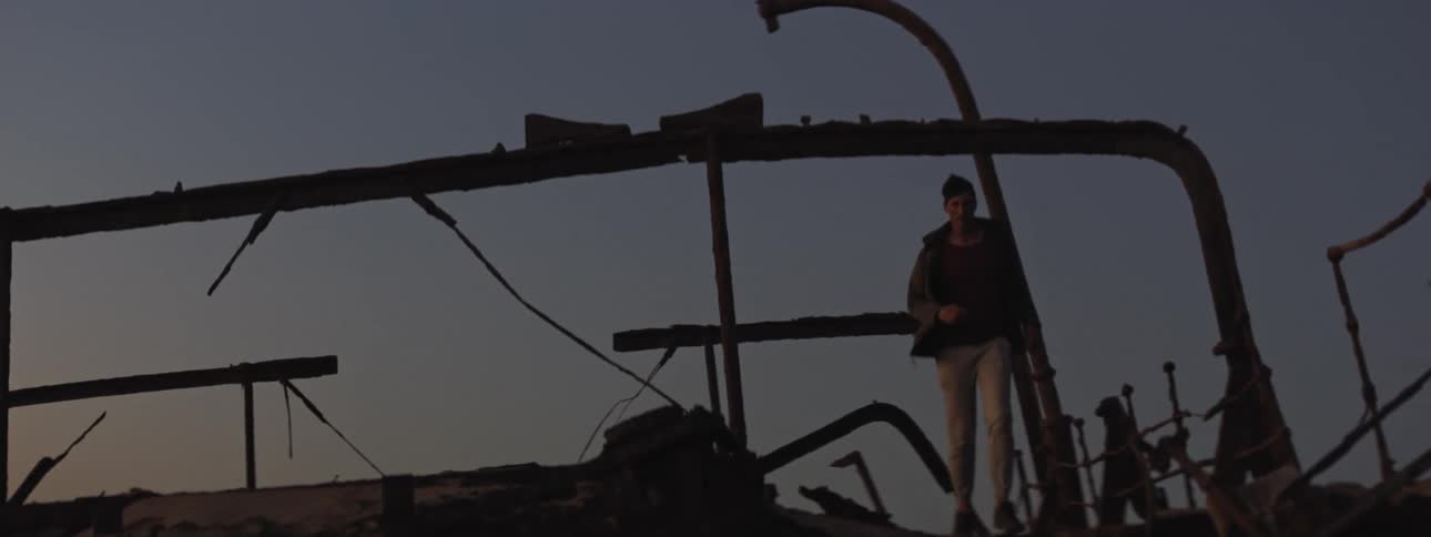 Youn man runs through ship wreckage