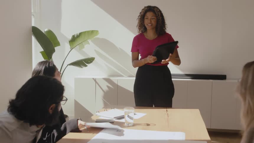 Woman greets her coworkers before presenting