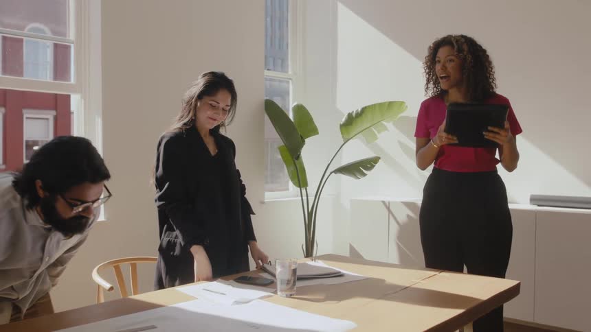 Confident black woman gets standing greeting from coworkers