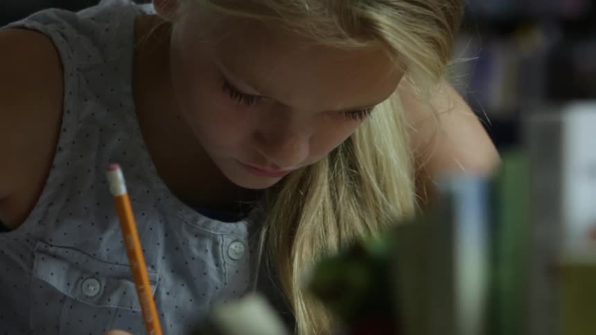 A girl is concentrating as she writes